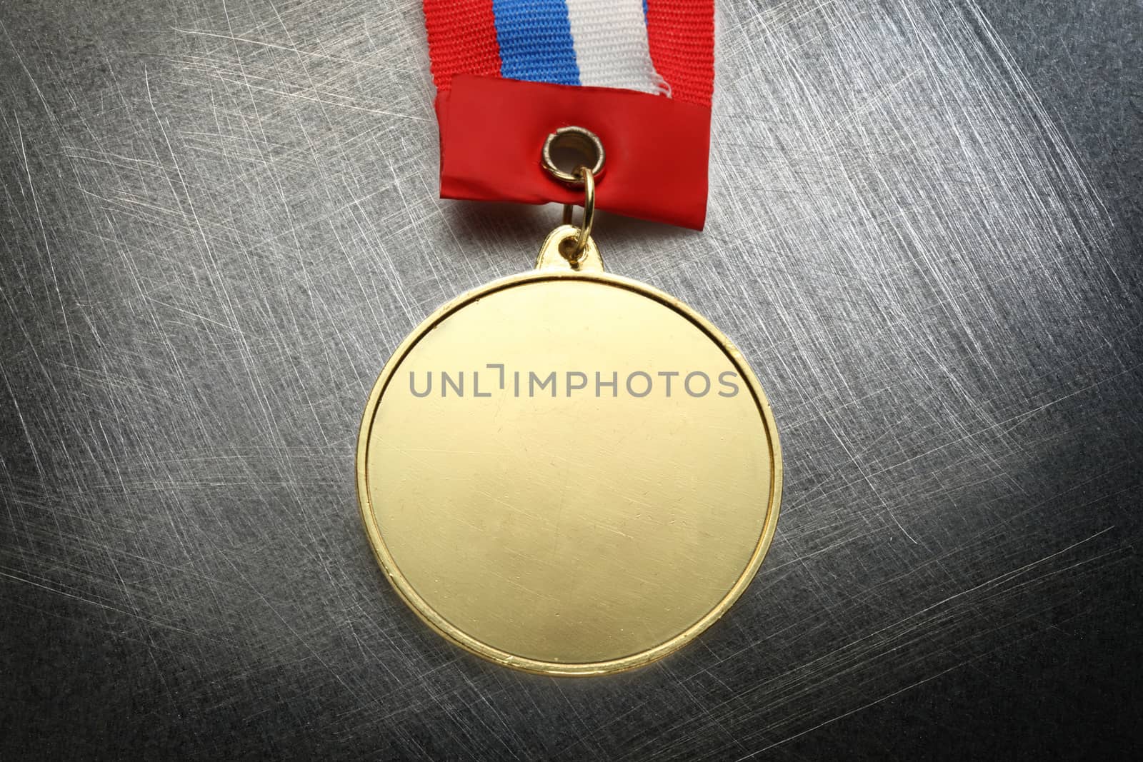 Metal medal with tricolor ribbon on steel scratchy background