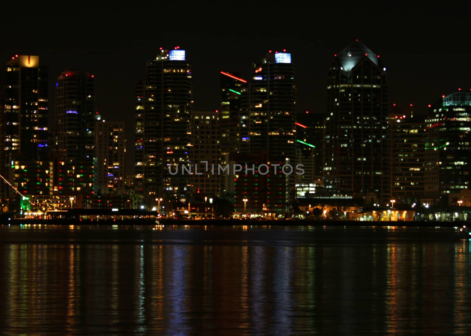 The skyline of San Diego at night with reflection in the water.