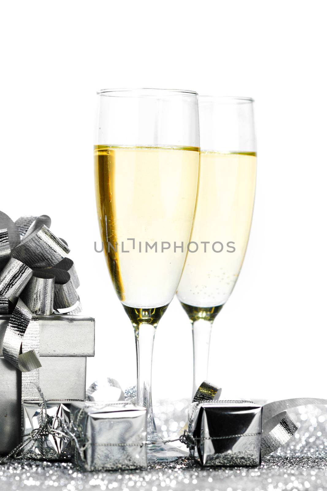 Glasses of champagne and christmas gifts on silver background