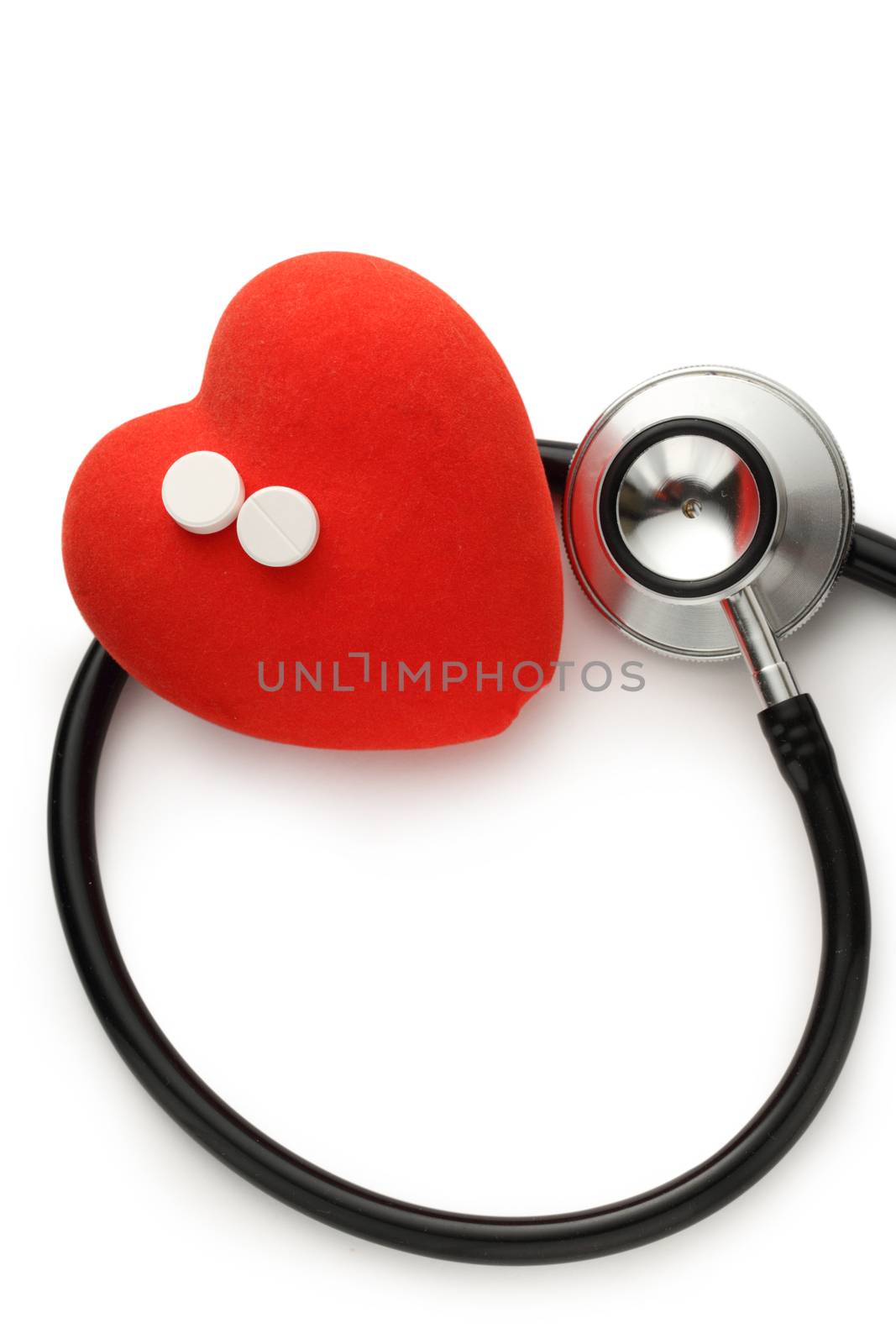 Red heart, stethoscope and pills on white background