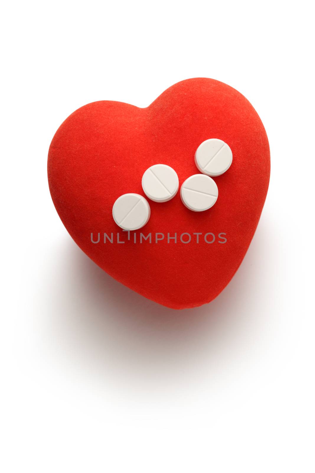 Red heart and pills on white background