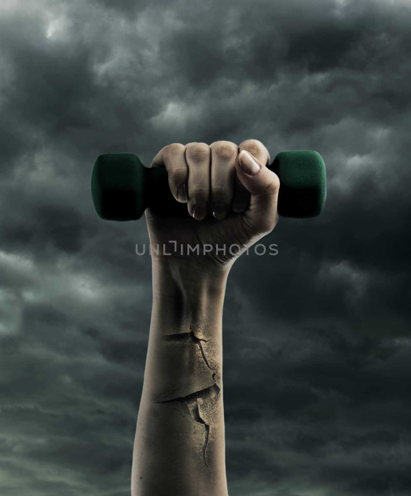 Dumbbell in hand on cloudy sky