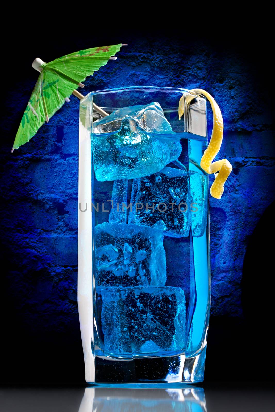 Blue curacao cocktail with decoration on wall background