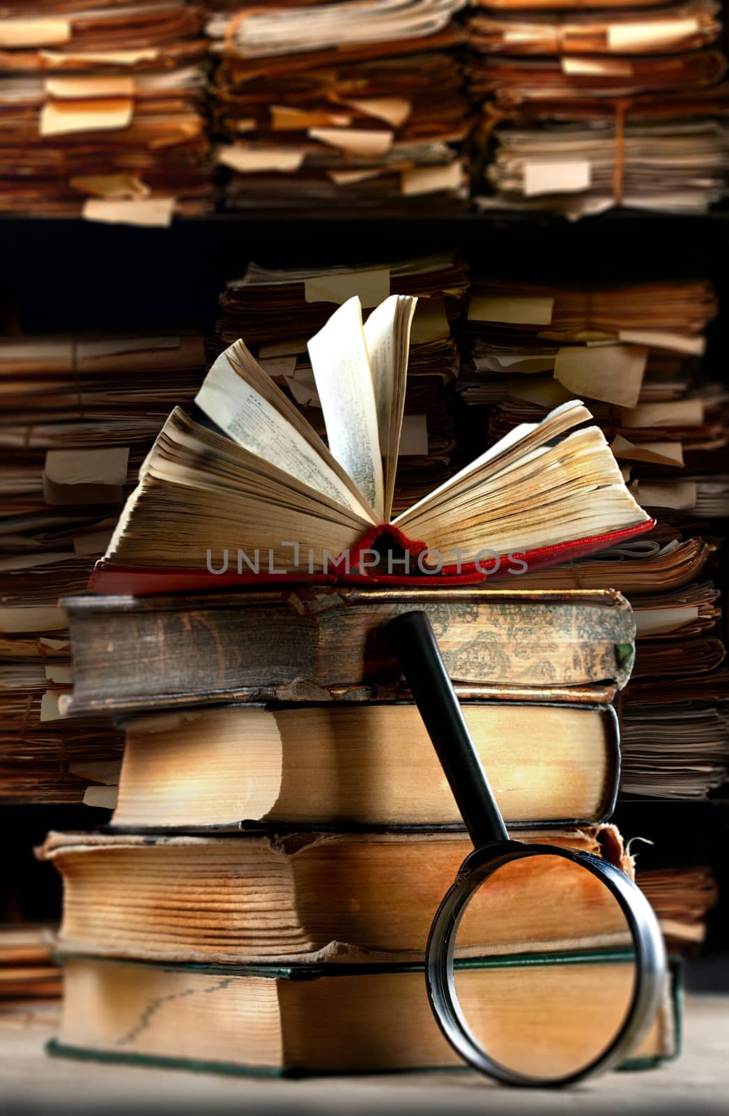 Old books with magnifying glass by Garsya
