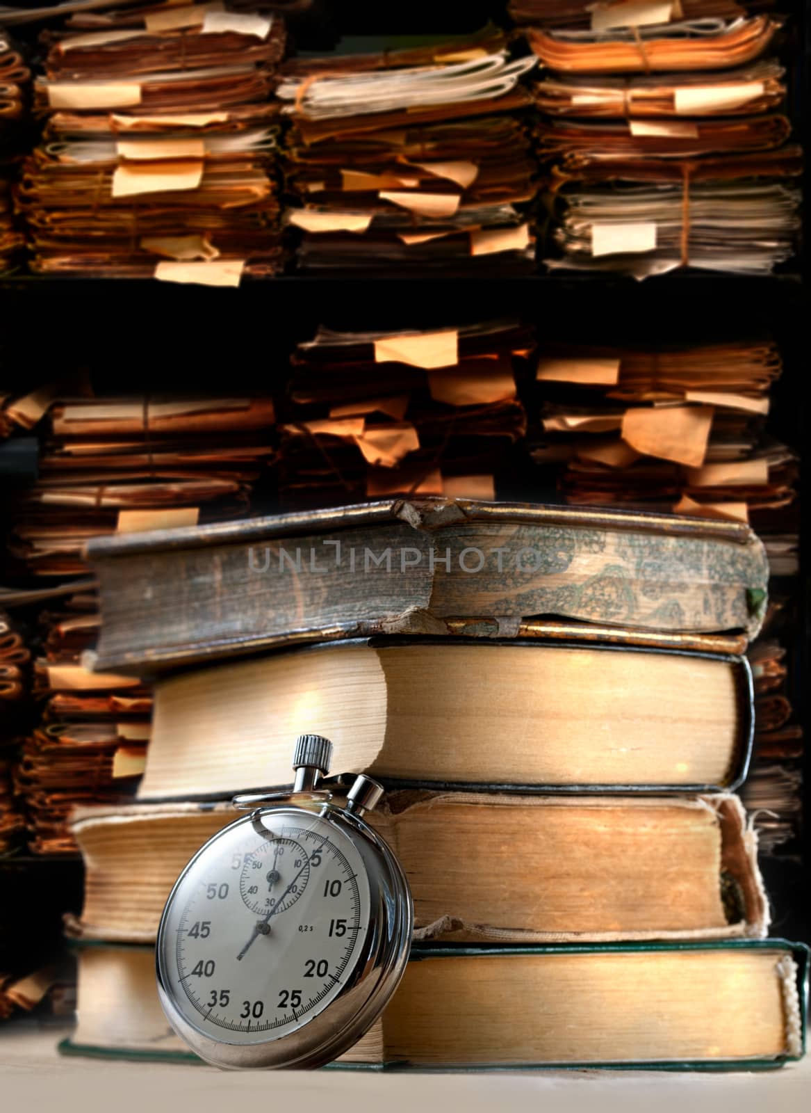 Pile of old books and stopwatch on archive folders background