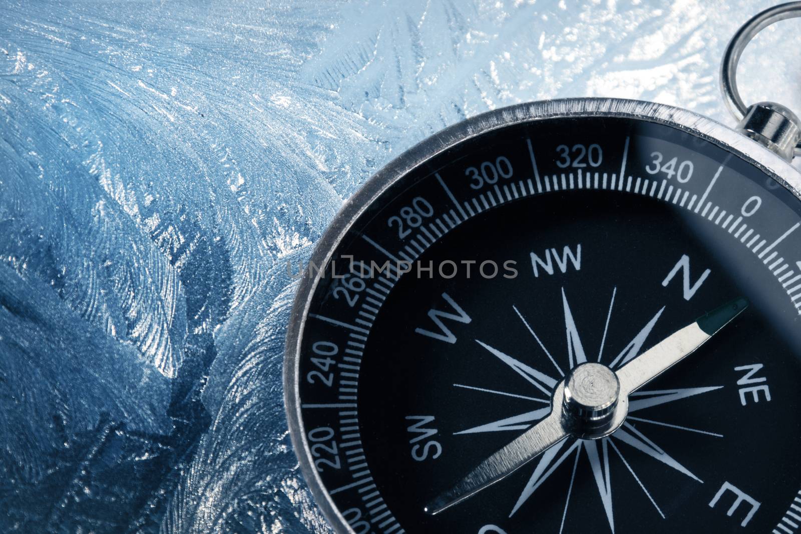 Black compass on icy background