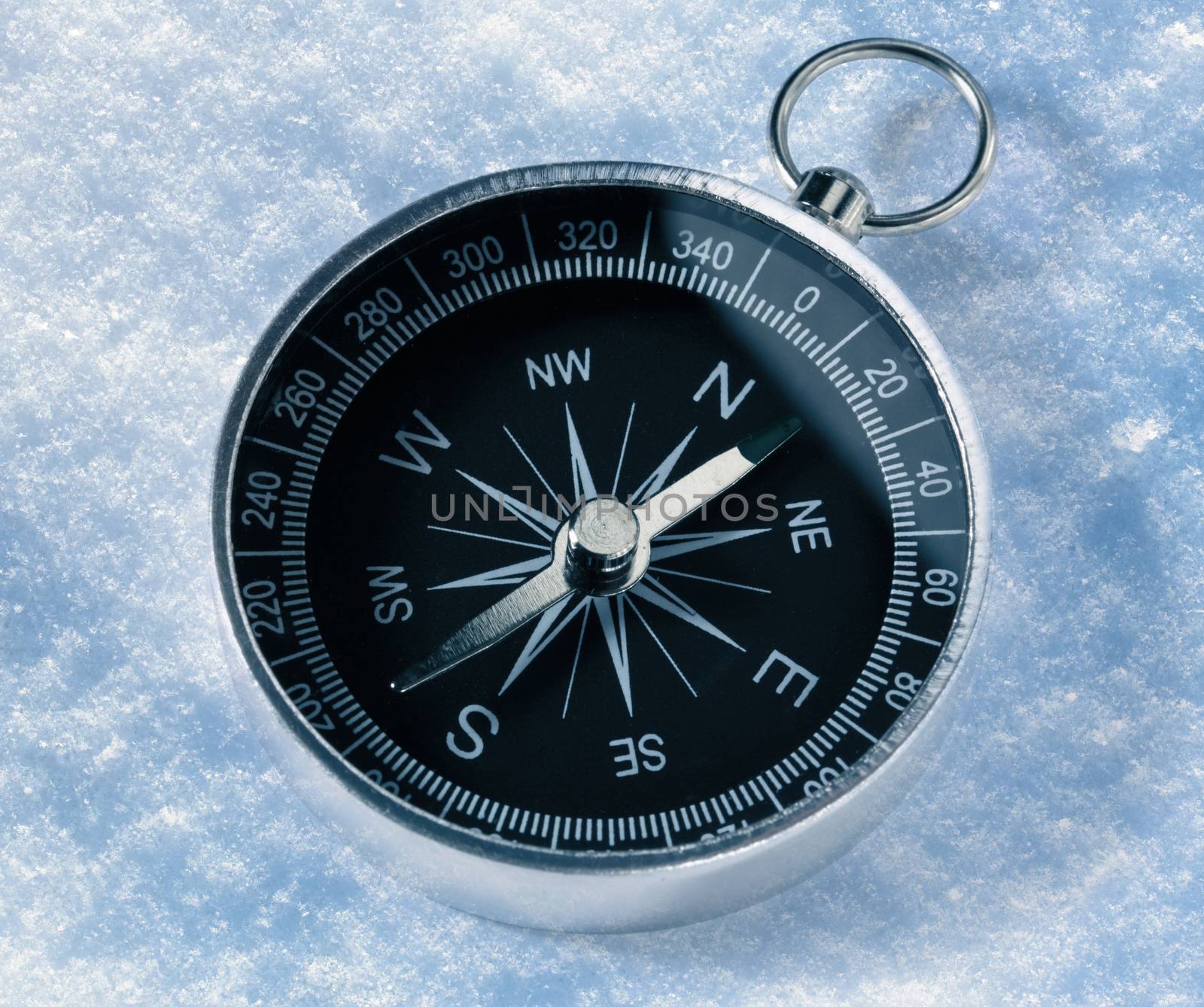 Black compass on snow background