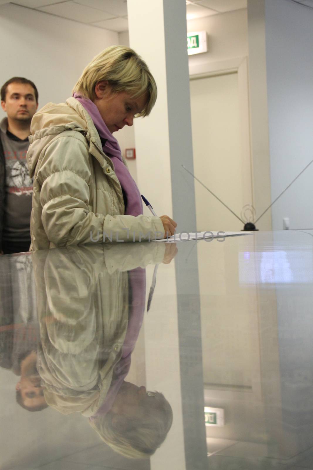 Khimki, Moscow region, Russia - October 14, 2012. Candidate for mayor of Khimki opposition Evgeniya Chirikova writes a complaint about violations at one of the polling stations. On election day in the suburban town of Khimki broke sharp competition between the candidate of the Kremlin Oleg Shahov and representative opposition Yevgenia Chirikova