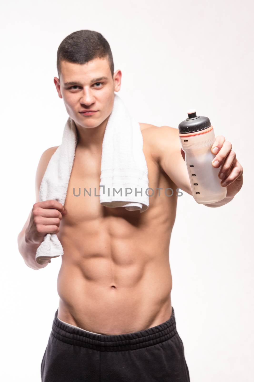 Muscular fitness man with bottle and towel - studio shoot 