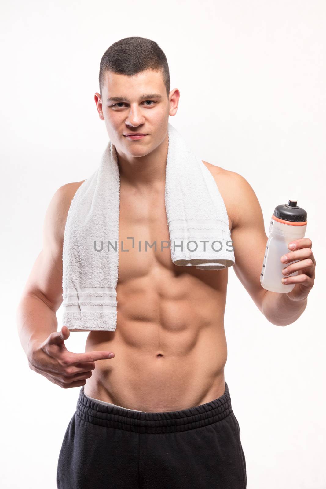 Muscular fitness man with bottle and towel - studio shoot 