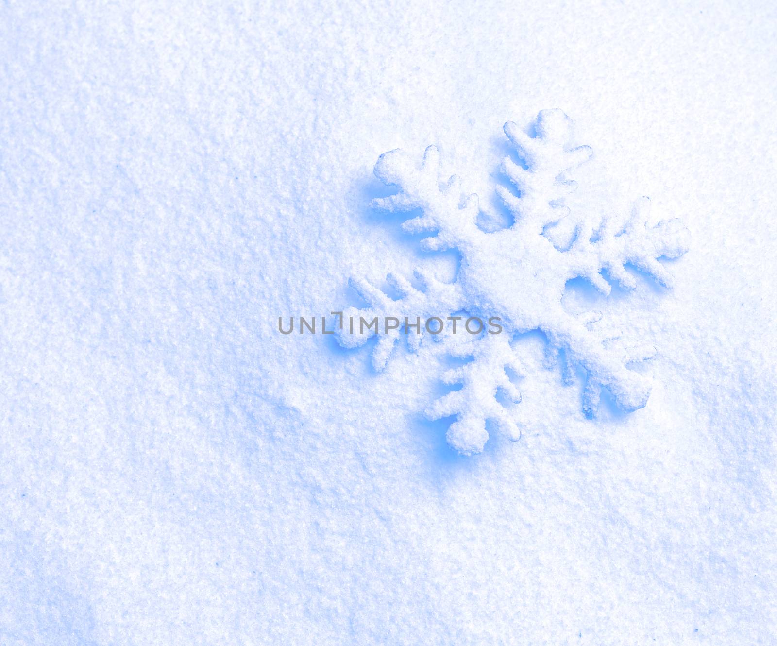 snowflake ornament against a background of snow