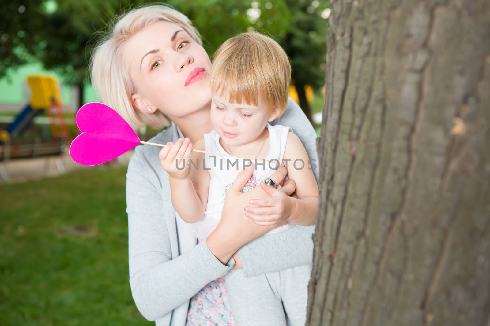 portrait of beautiful mother and kid girl outdoors in park by sarymsakov