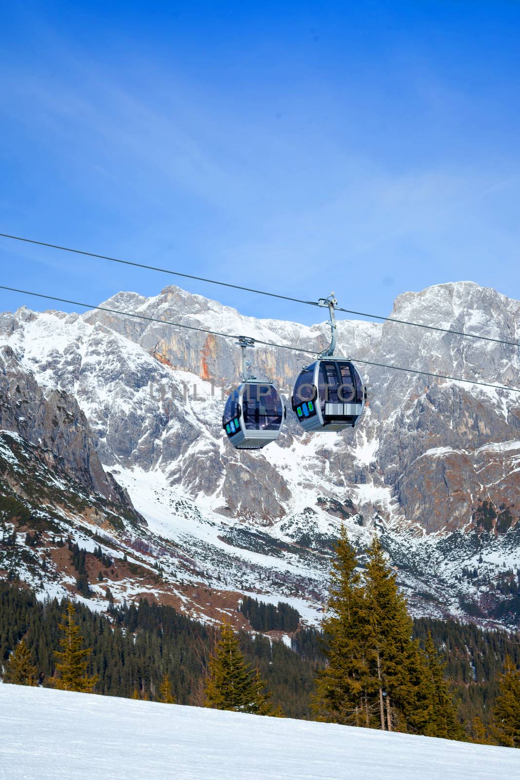 Cable car on the ski resort in Austria. On the background mountain and blue sky.