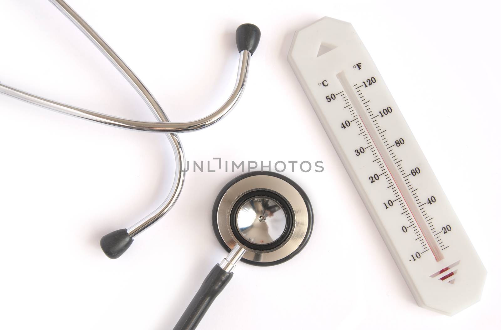 Medical stethoscope and thermometer over a white background