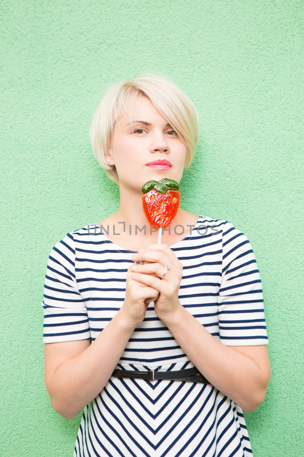 Young sexy woman sucking lollipop. Urban style. Outdoors, lifestyle.