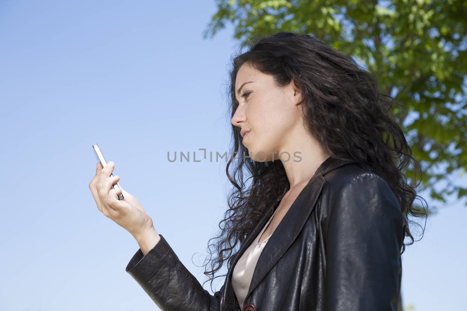 woman watching and talking to smartphone in exterior background