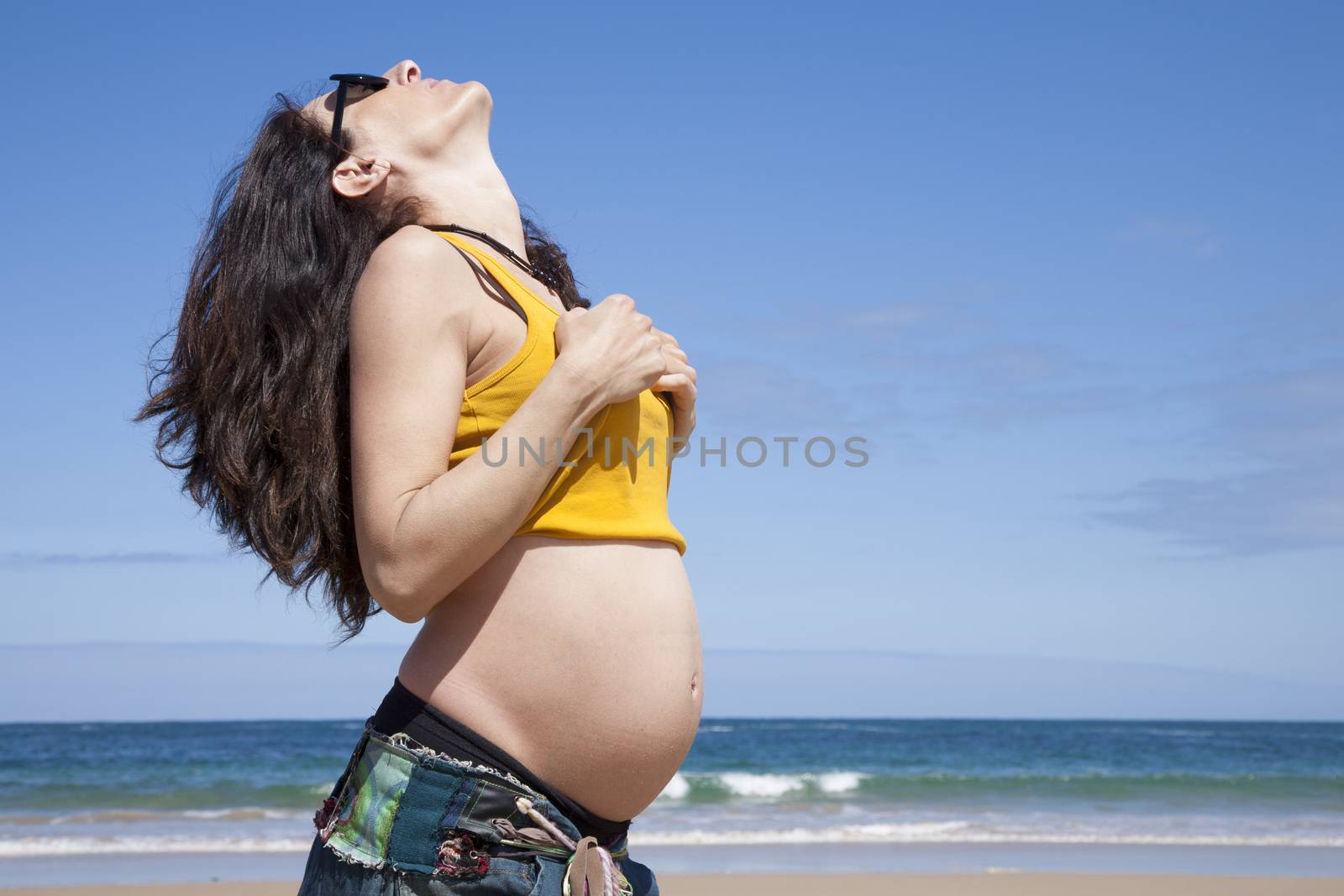 pregnant woman showing her paunch at Asturian beach