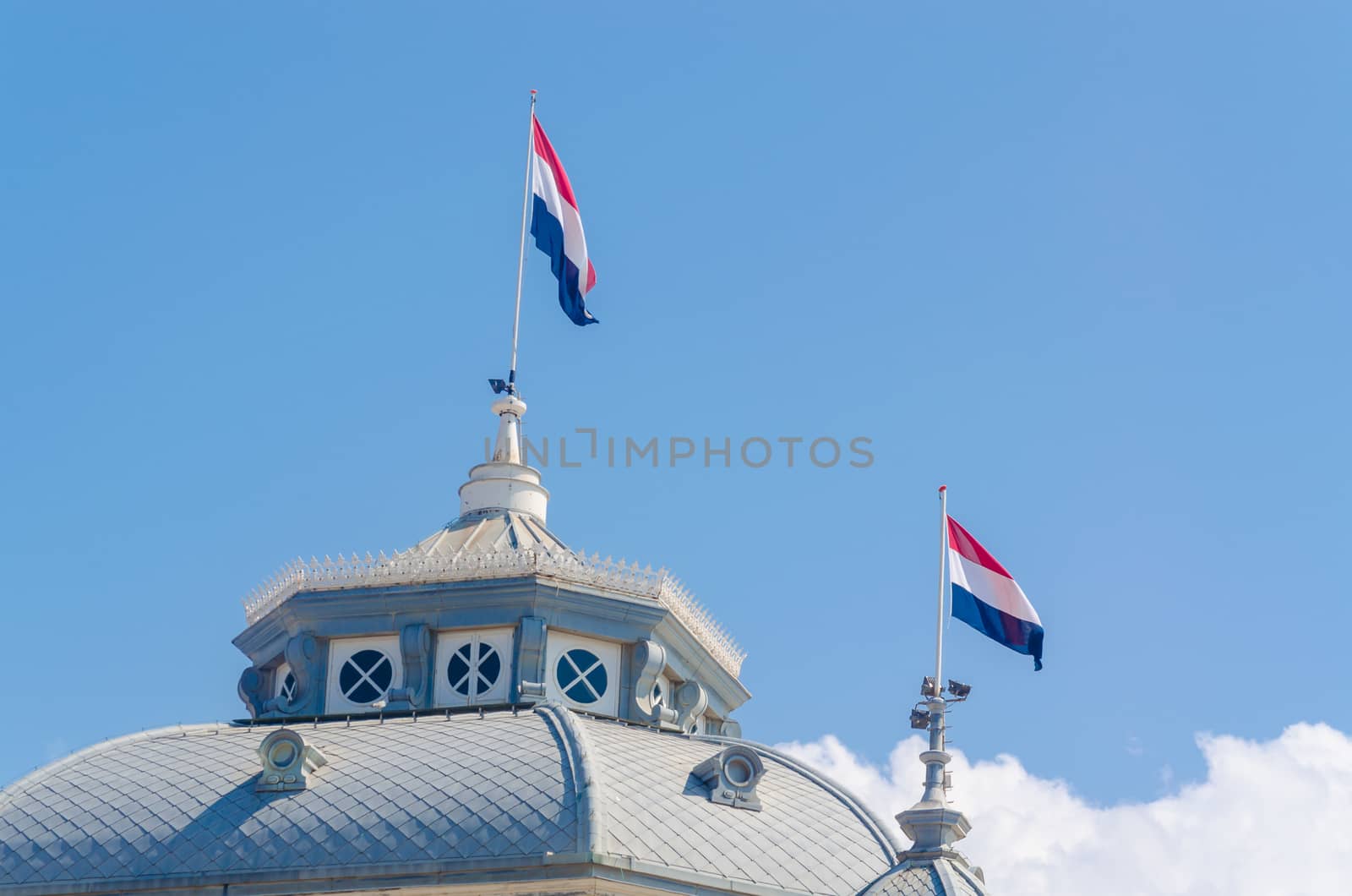 Gable view with flags of the Kurhaus in Scheveningen Netherlands, Holland against a blue sky.