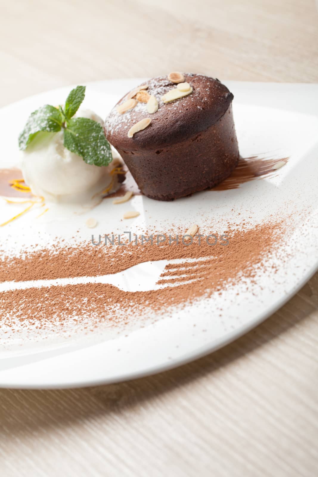 Warm dessert chocolate cake Fondant served on plate with ice-cream ball, almond chips, mint, icing, citron, cacao