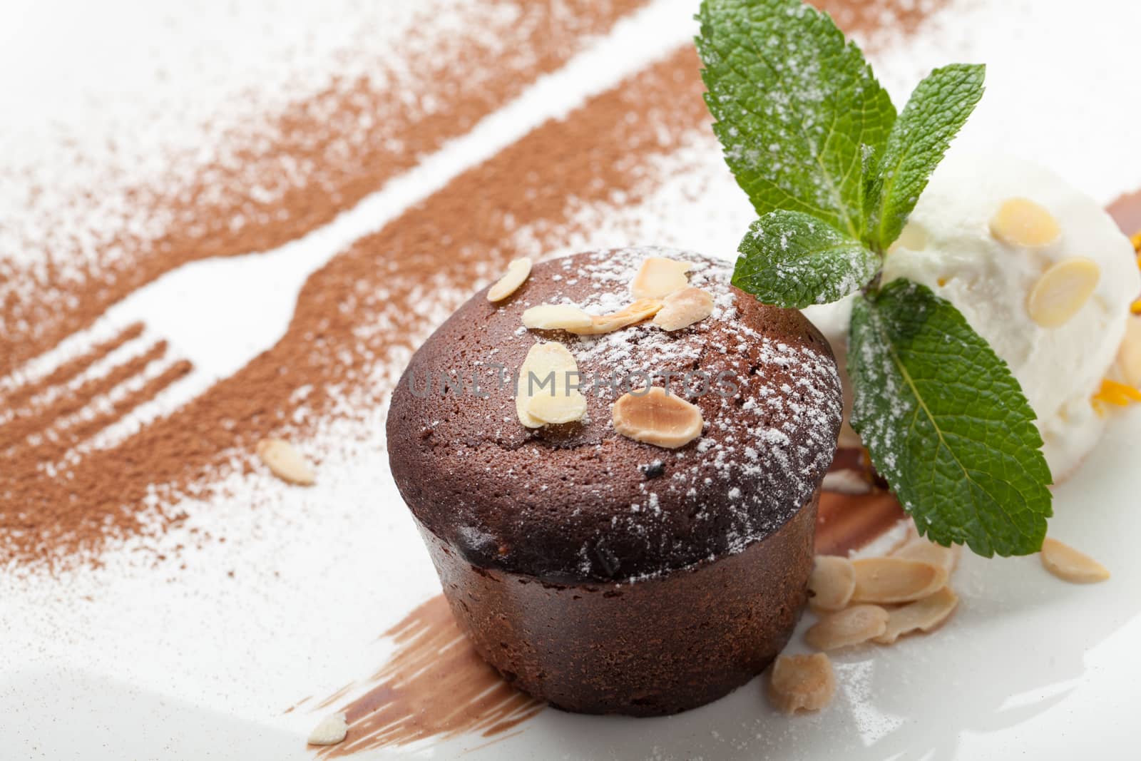 Warm dessert chocolate cake Fondant served on plate with ice-cream ball, almond chips, mint, icing, citron, cacao