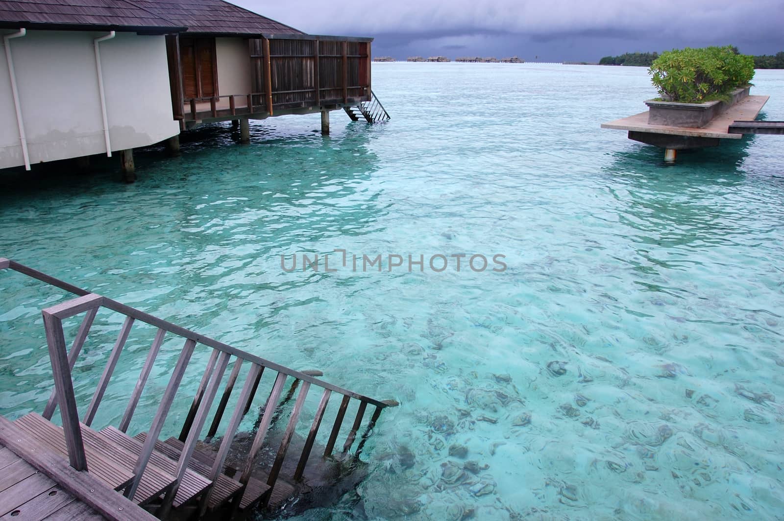 Timber steps down to water from pier resort Maldives