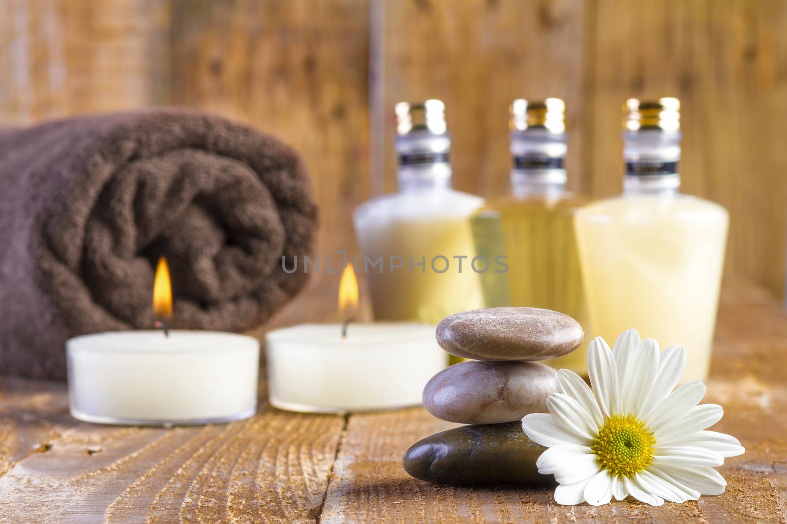 zen basalt stones and spa oil with candles on the wood