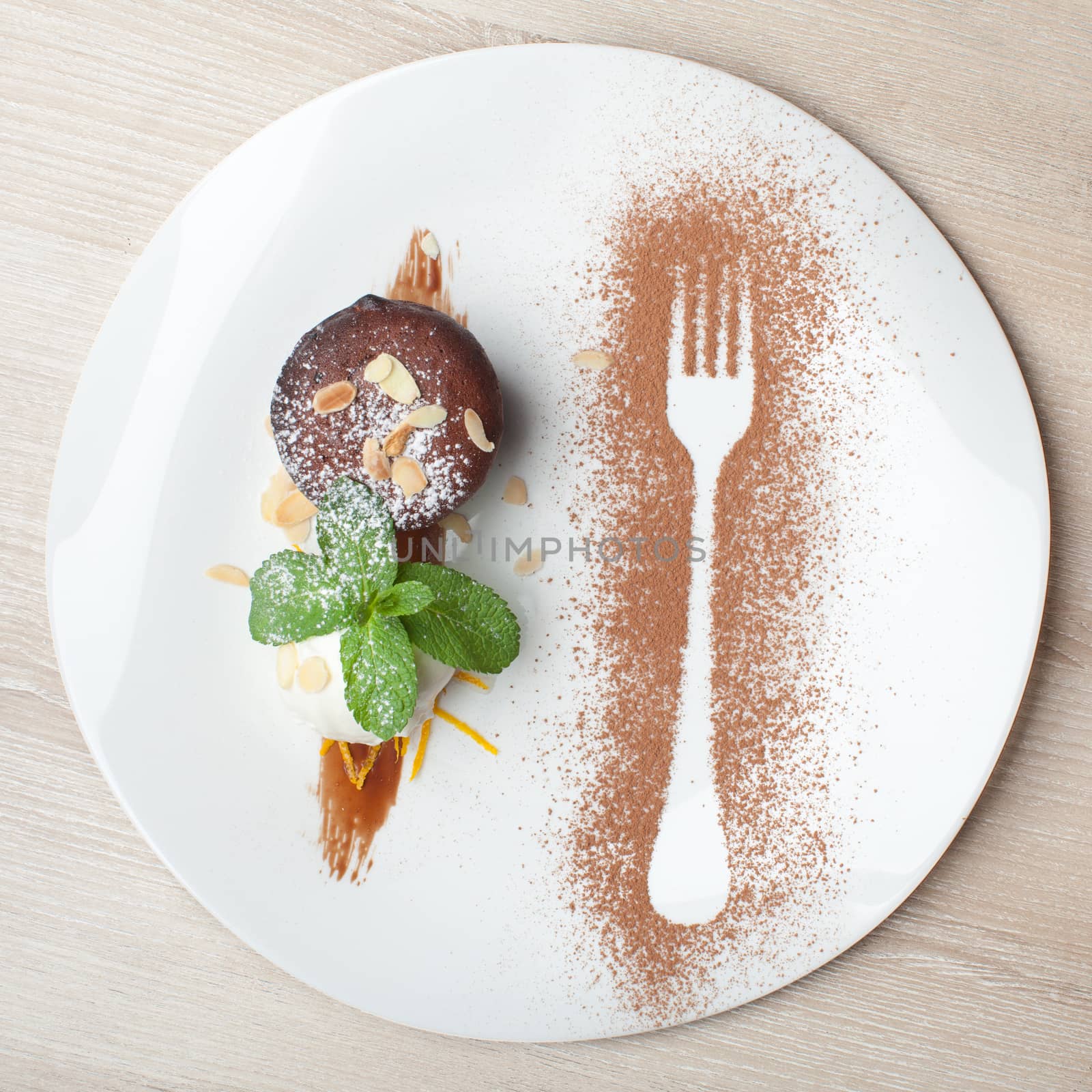 Warm dessert chocolate cake Fondant served on plate with ice-cream ball, almond chips, mint, icing, citron, cacao