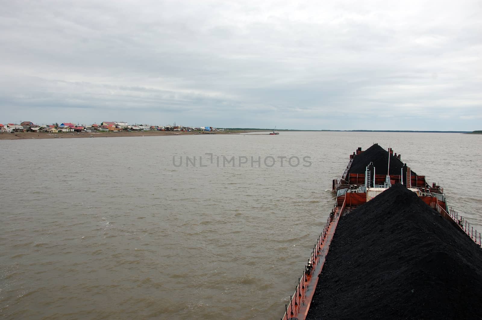 Ship with coal at Kolyma river near village by danemo