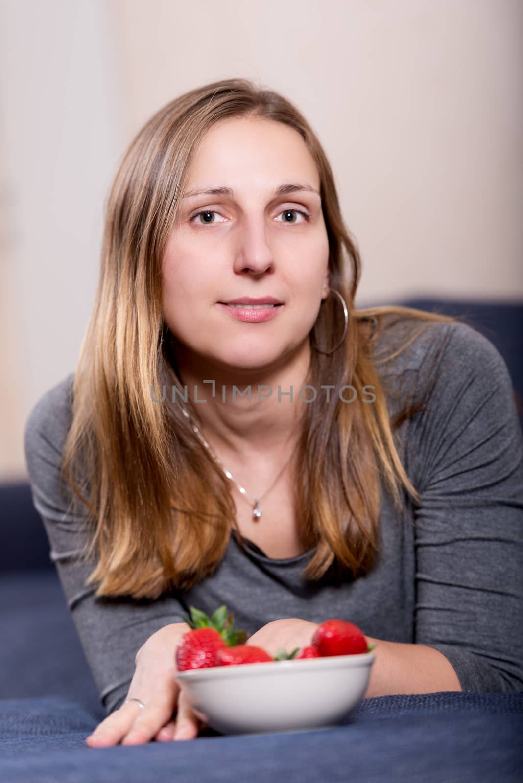 Young brunette woman with strawberry vertical by Nanisimova