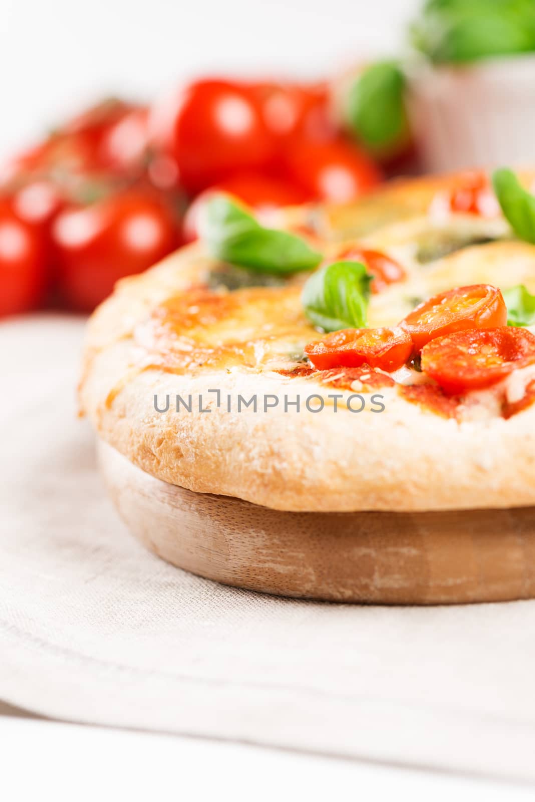Delicious italian pizza on tablecloth with tomatoes