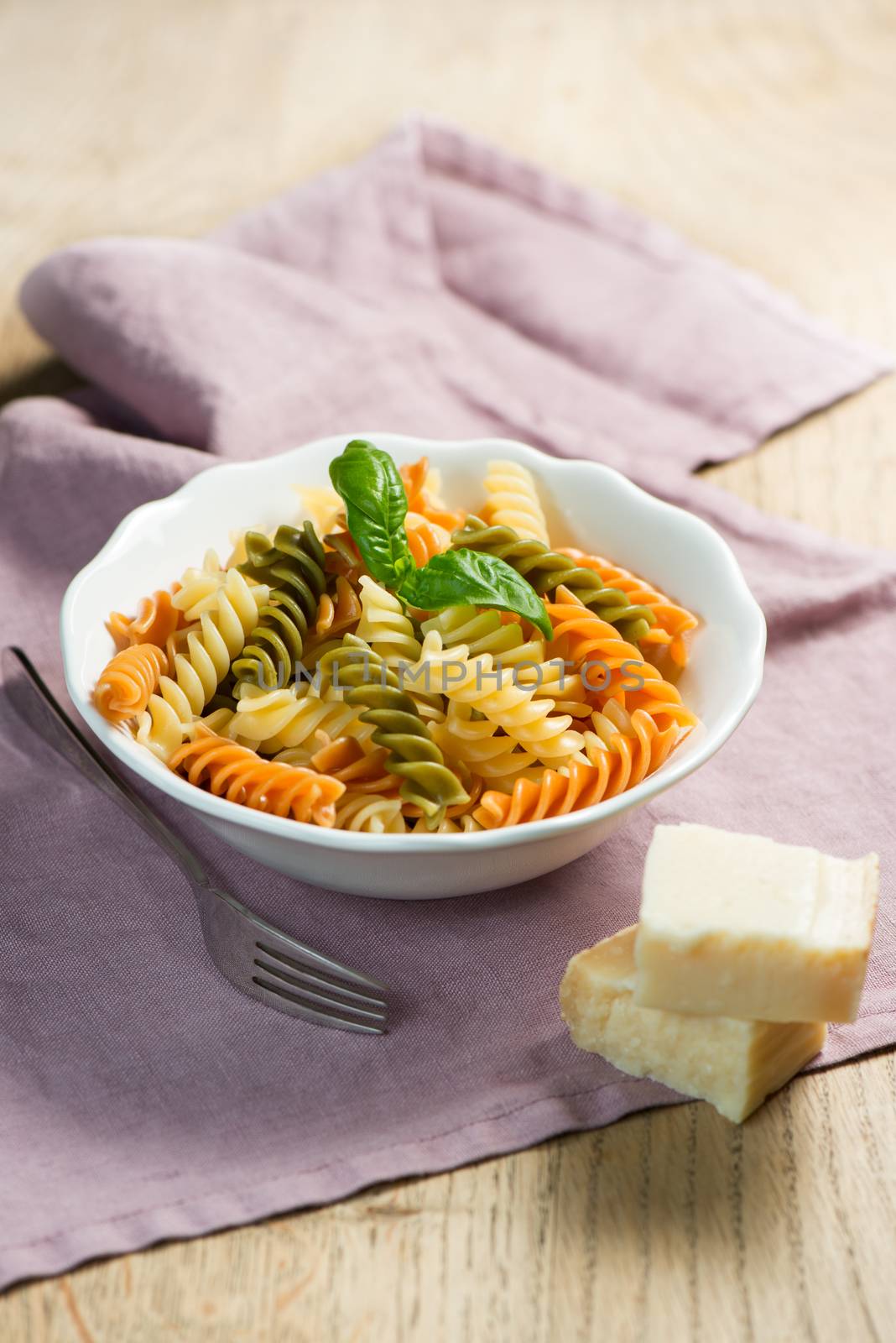 Pasta and basil in a bowl with hard cheese