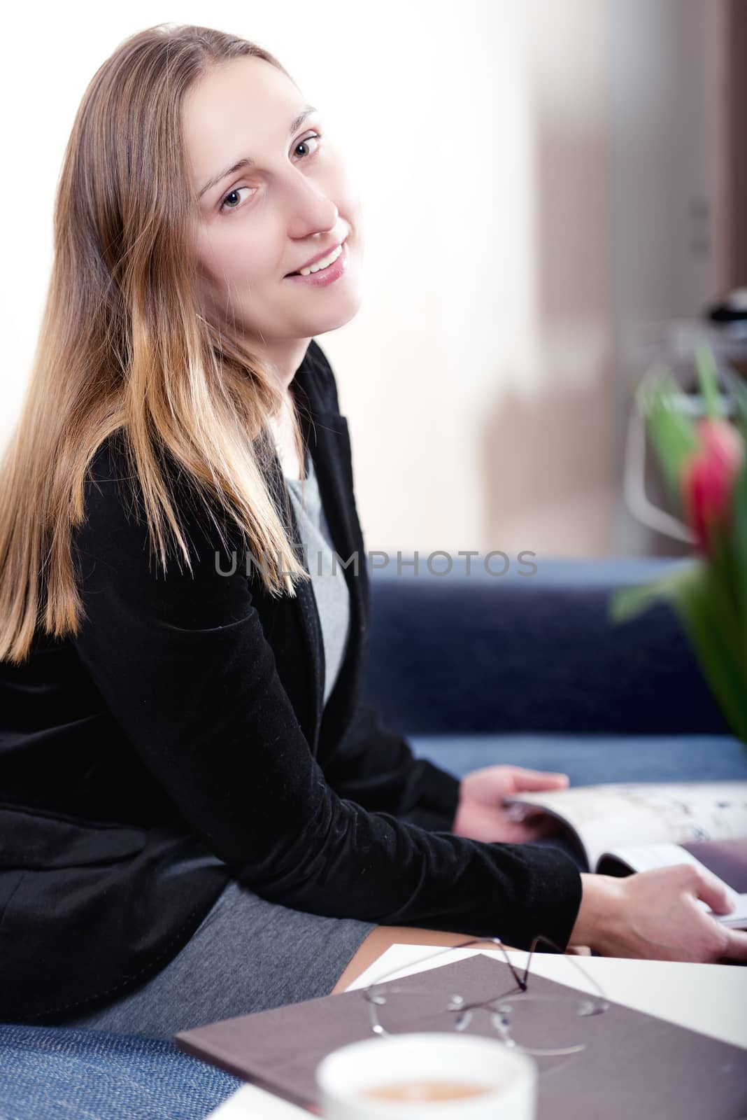 Portrait of elegantly dressed young brunette woman looking at camera