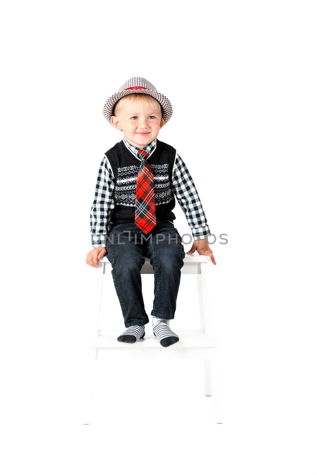 Smiling happy boy with tie and hat shot in the studio on a white background