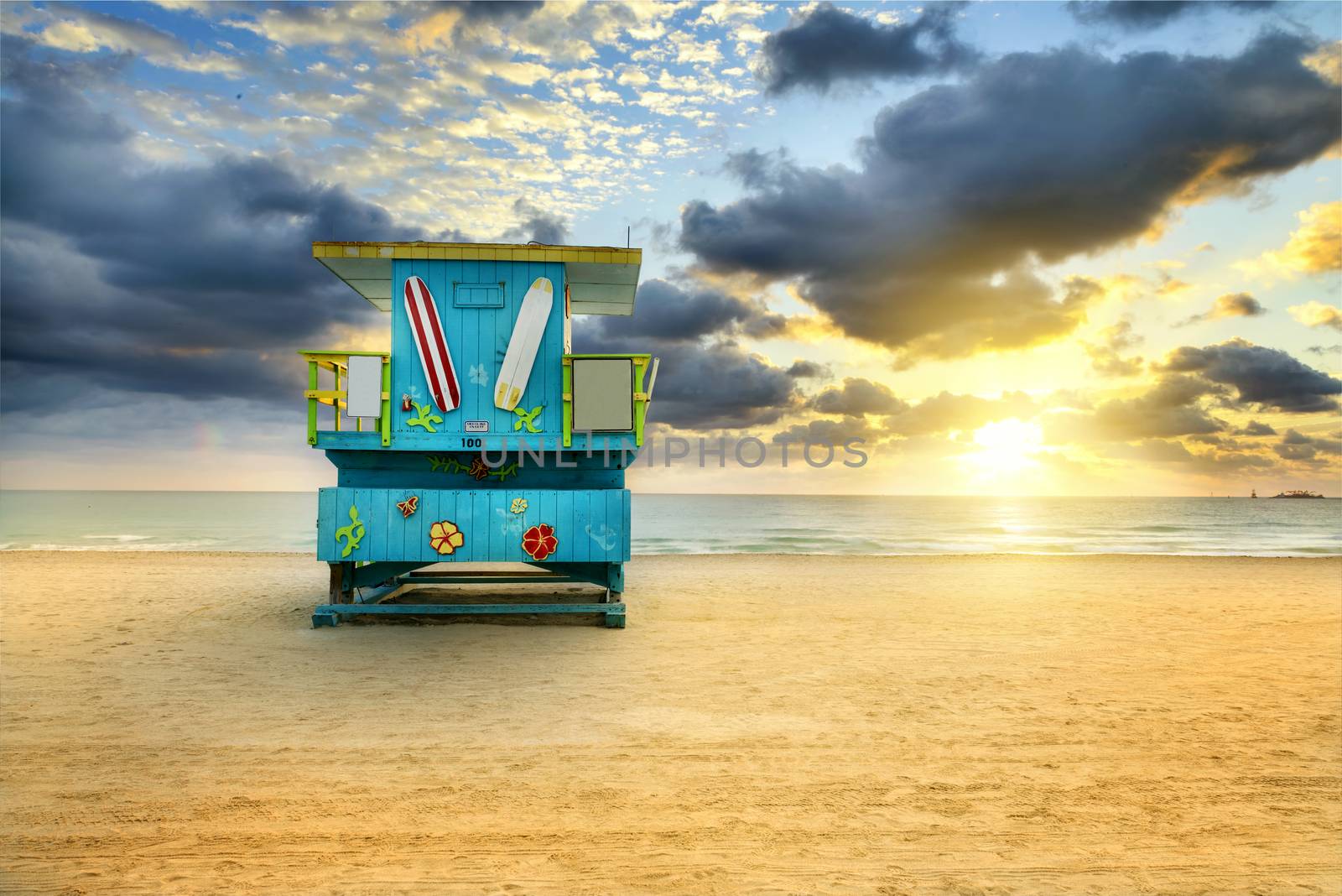 Miami South Beach sunrise with lifeguard tower and coastline with colorful cloud and blue sky. 