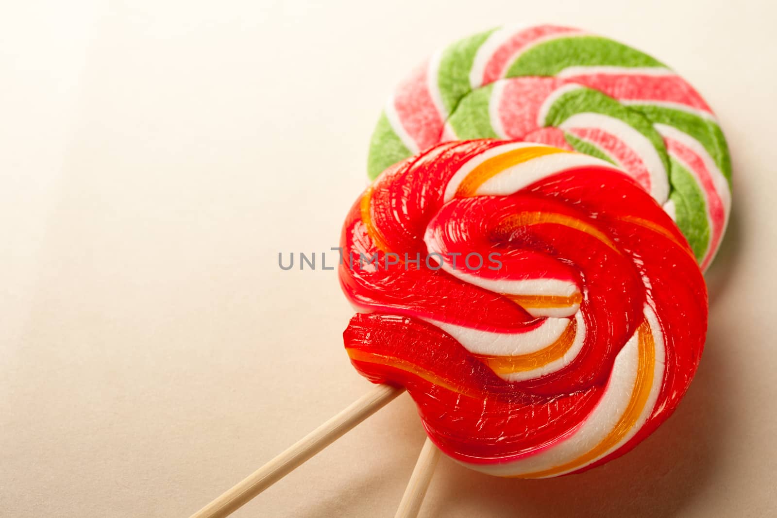 Bright lollipop candy on paper background by Garsya