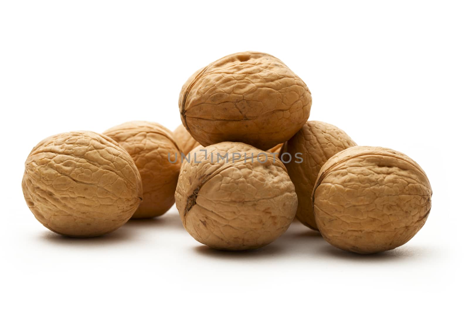 Heap of walnuts on white by Garsya