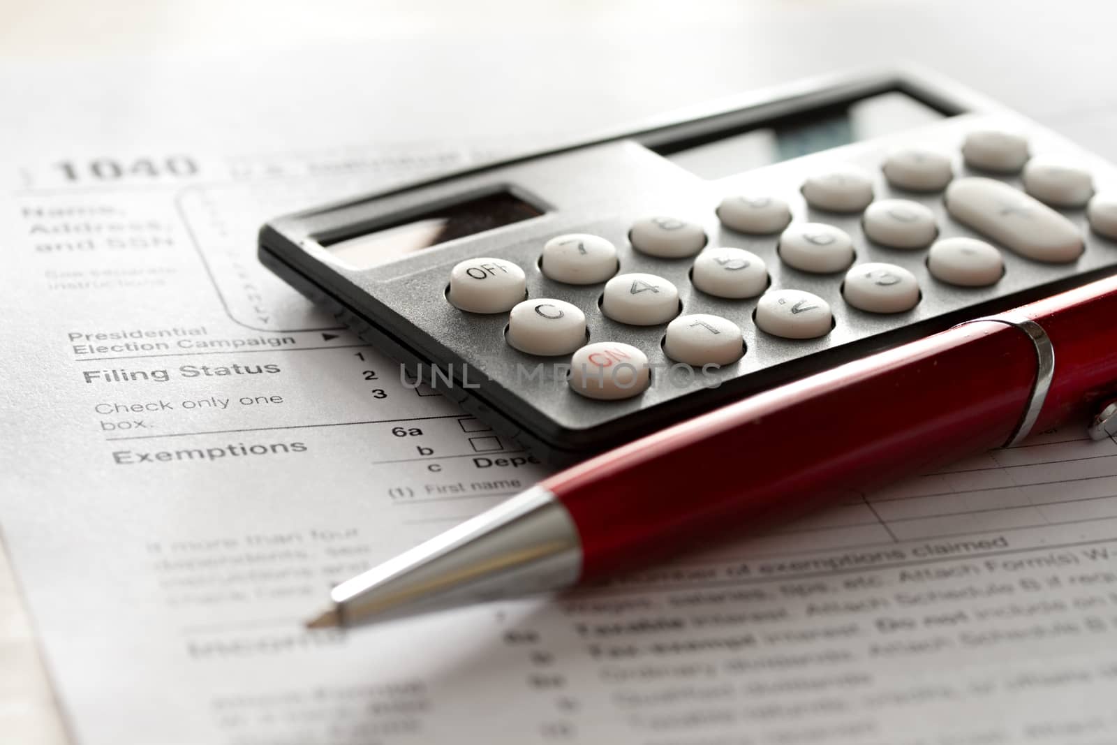 Tax form, red pen and calculator by Garsya