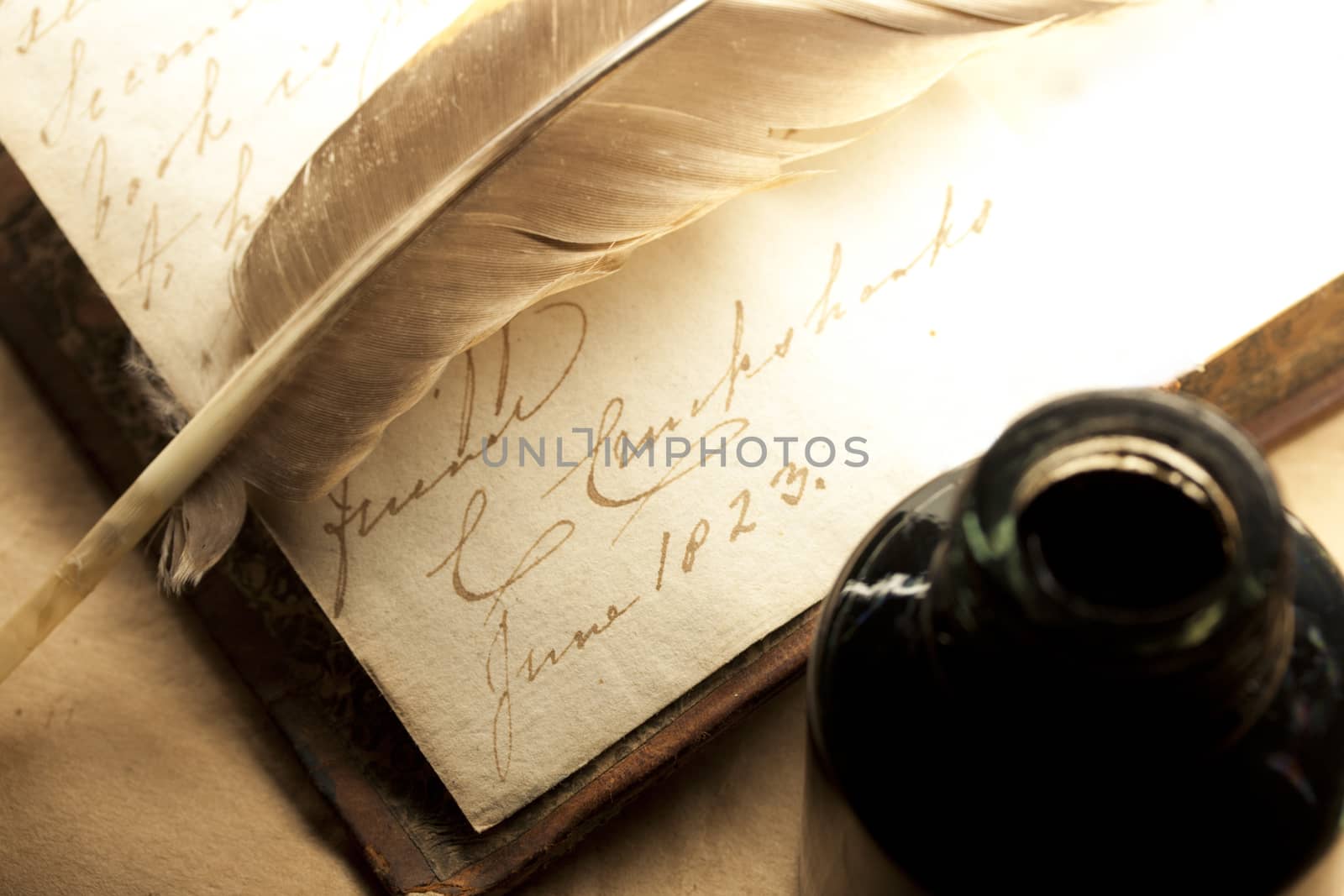 Old book with feather and inkpot 