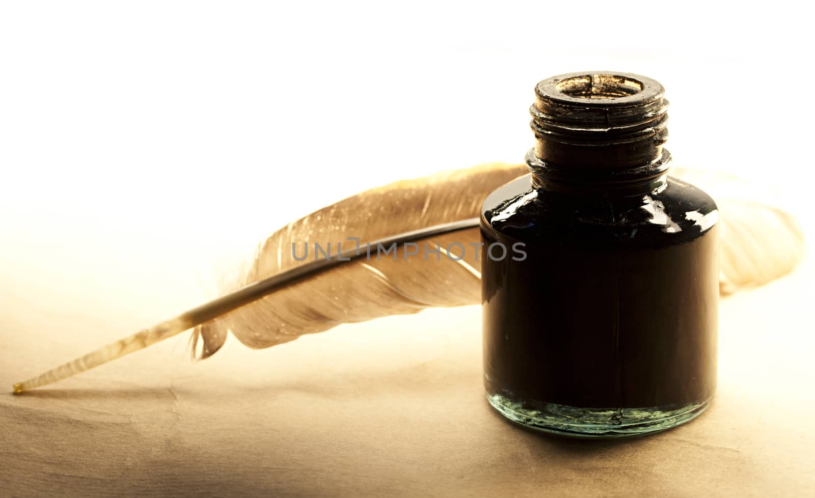 Feather and inkpot on paper