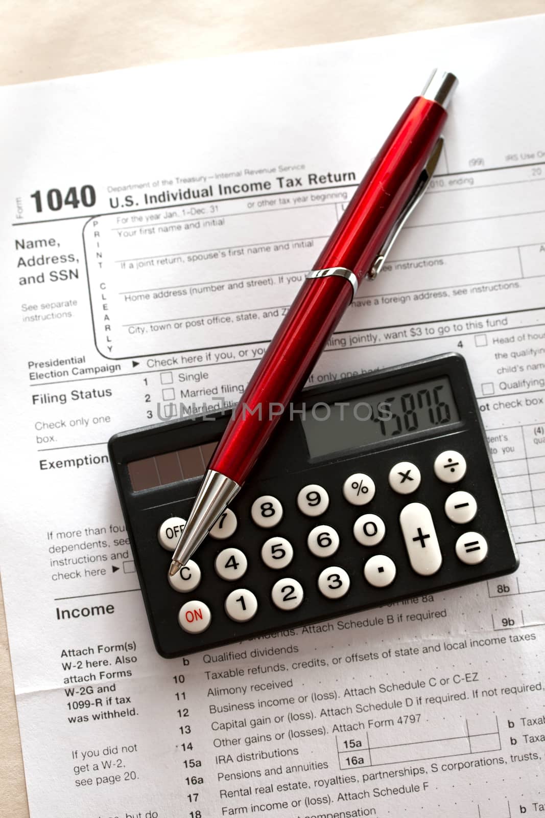 Tax form, red pen and calculator by Garsya