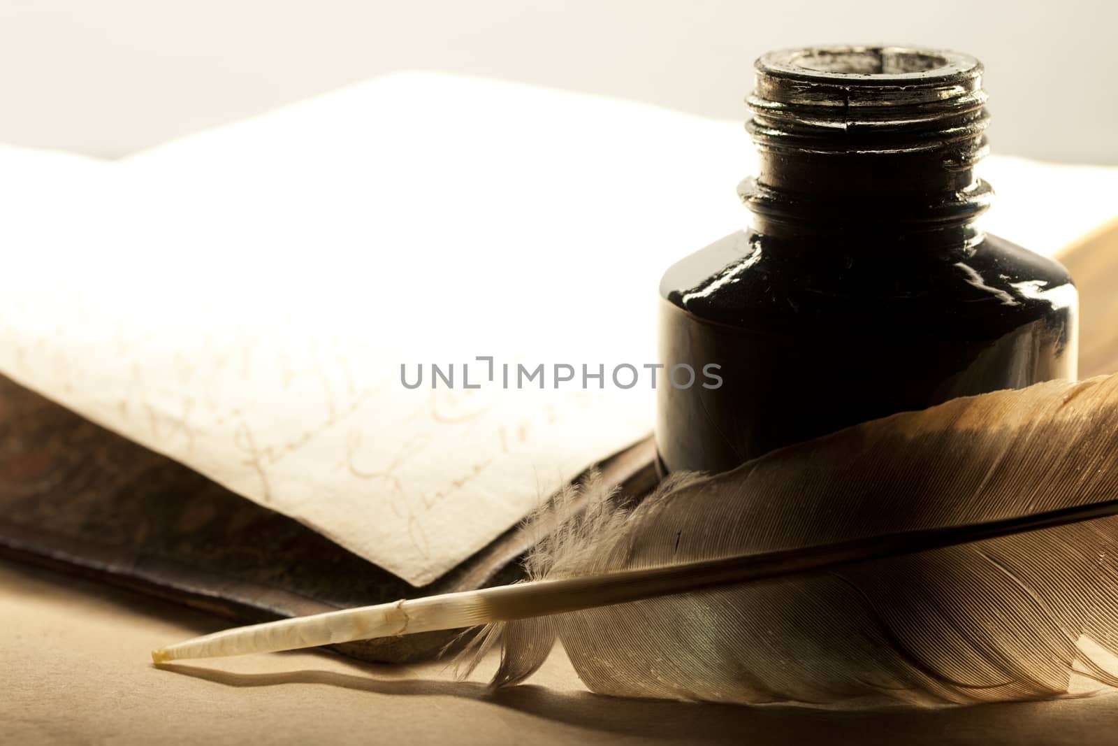 Old book with feather and inkpot 