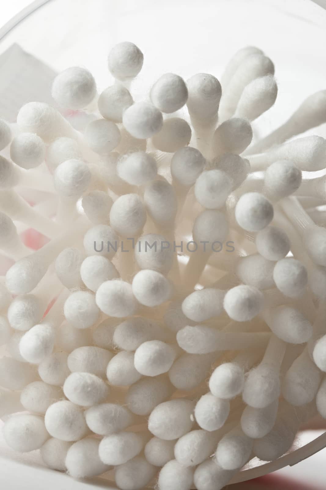 White cotton swabs in plastic container by Garsya