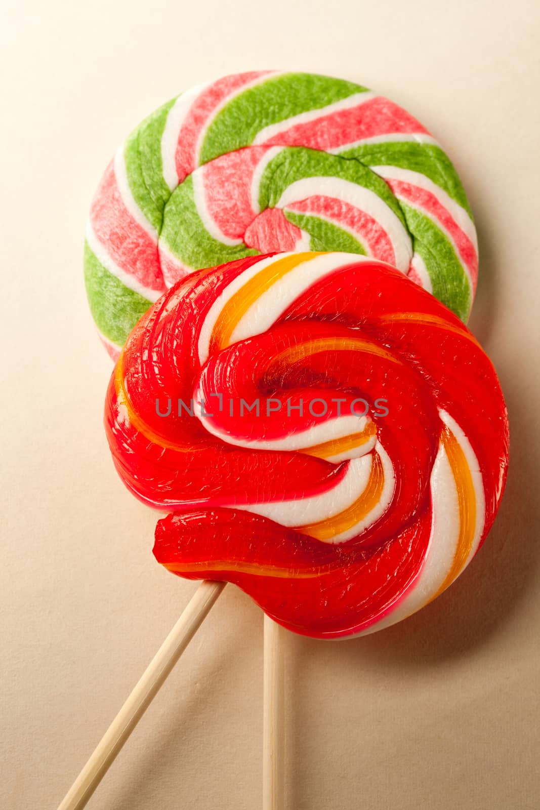 Bright lollipop candy on paper background by Garsya