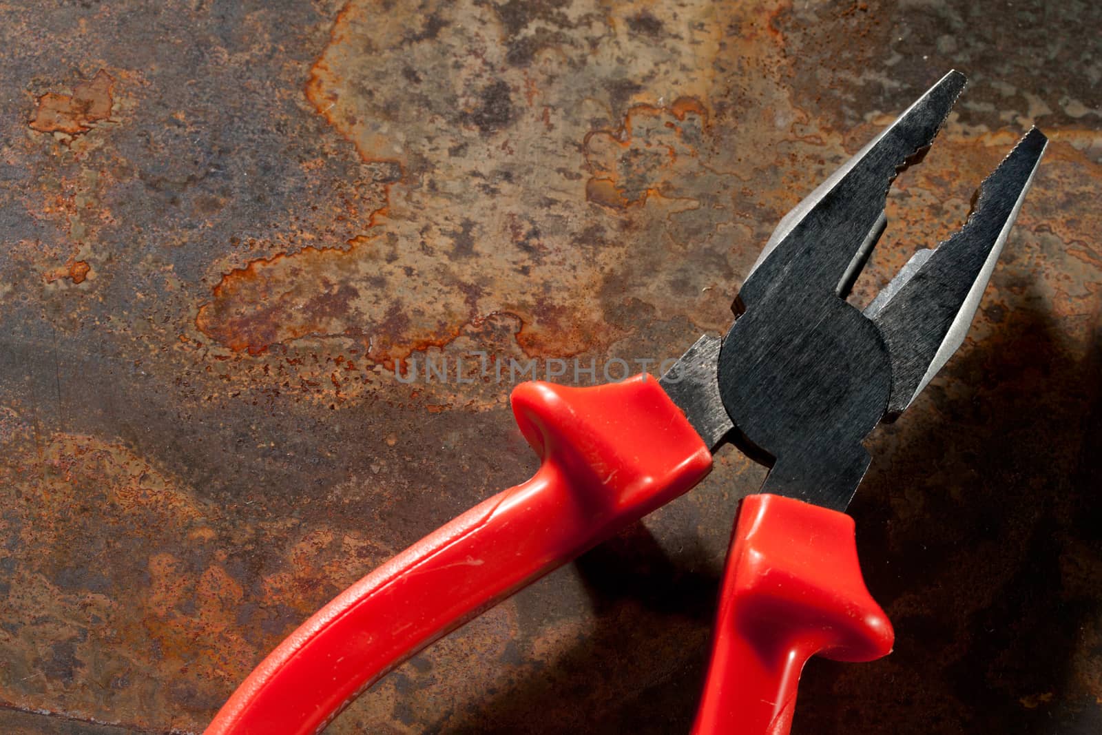 Pliers on the rusty plate