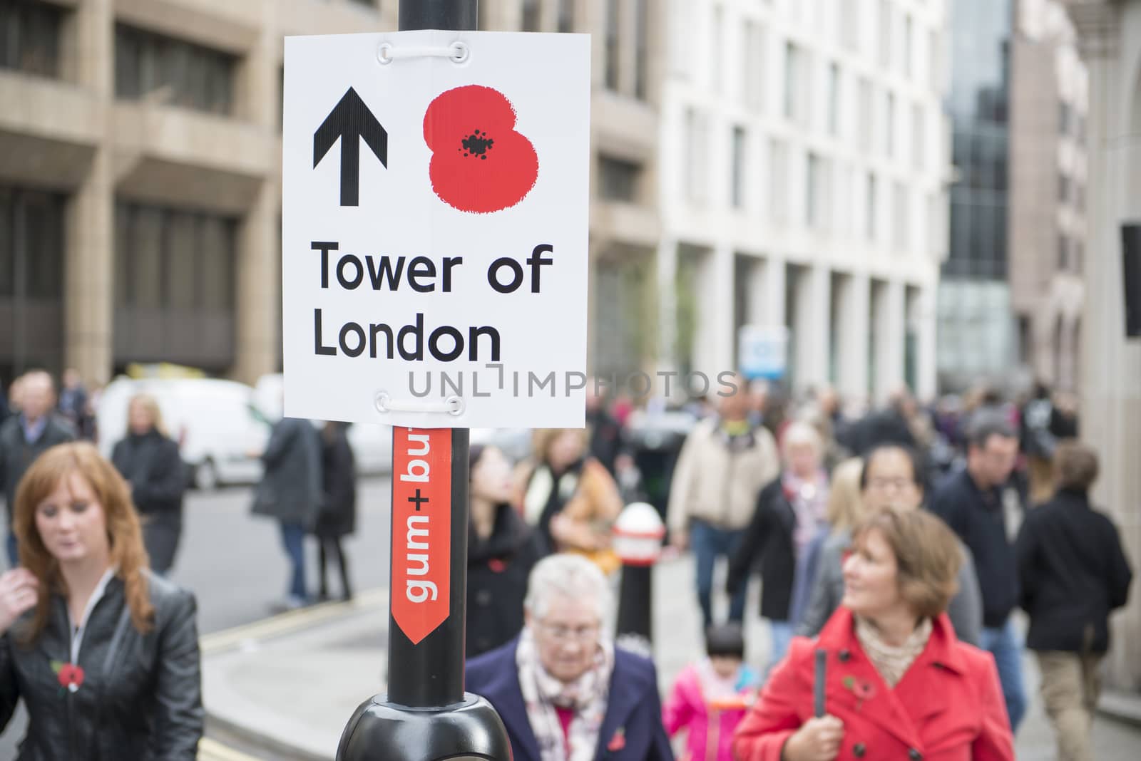 LONDON, UK - NOVEMBER 08: Street sign with red poppy pointing to the Tower of London. November 08, 2014 in London. The ceramic poppies installation was created to mark the centenary of WWI's outbreak.