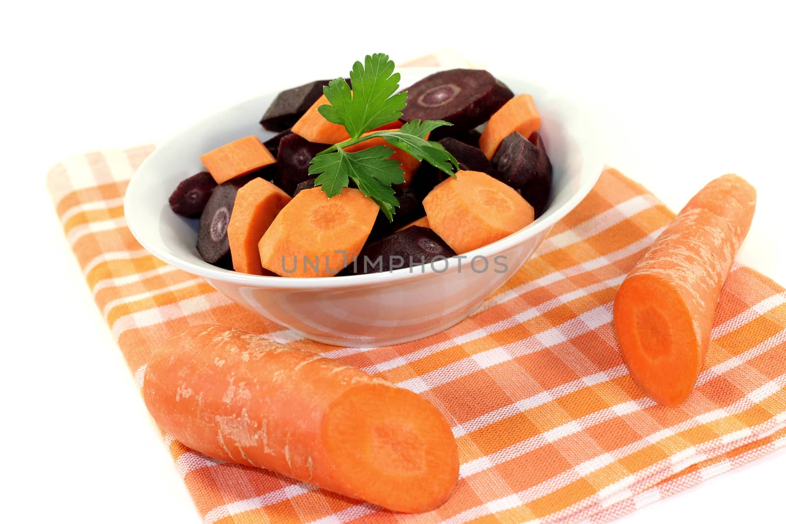 orange and purple carrots with smooth parsley on a light background