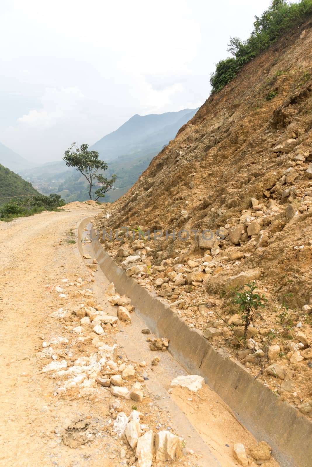 Rock fall into below of Mountainside beside abandon road