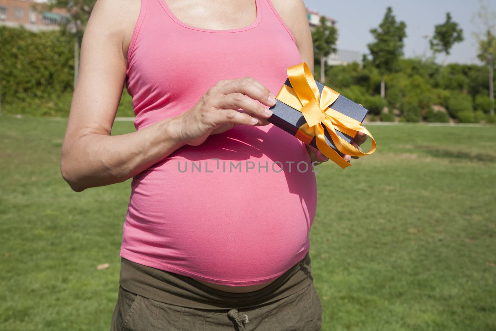 pink pregnant woman with gift in her hands
