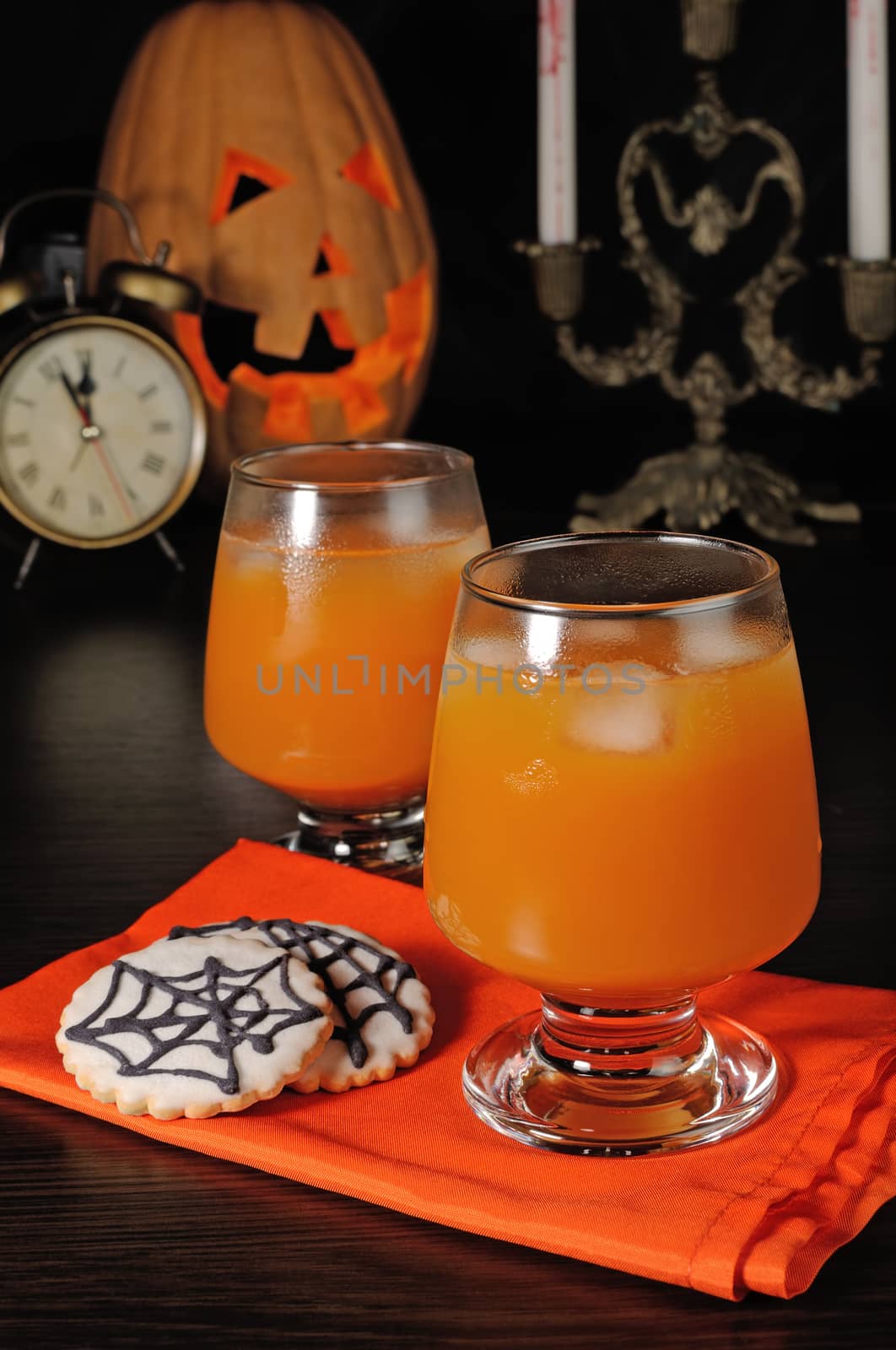 Pumpkin juice with ice on a napkin with cookies for Halloween