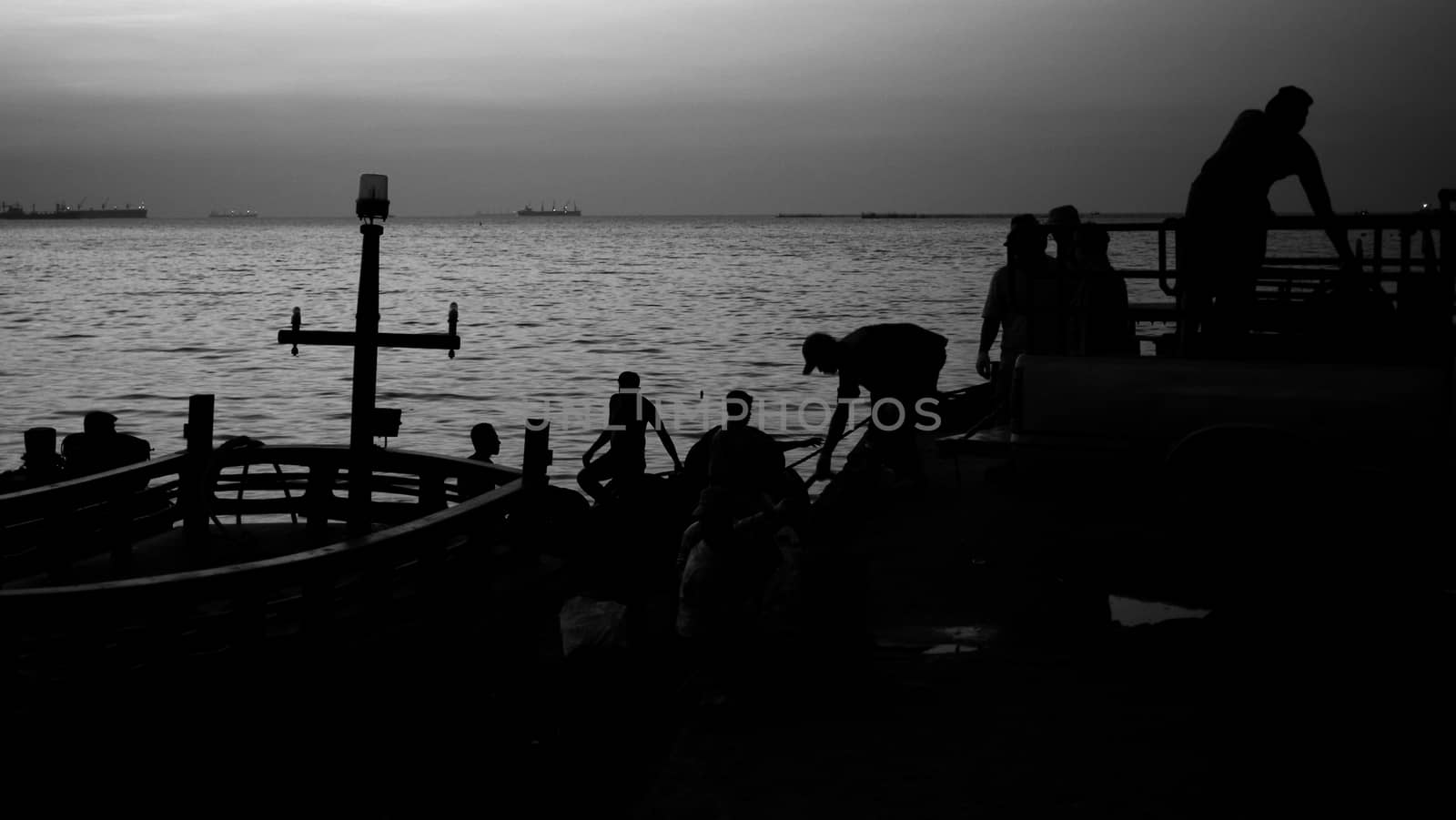 Silhoutte of fisherman work at port by pixbox77